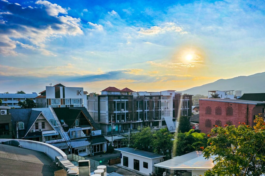 Chiang Mai skyline. Blue hour with the sun going down in the background and some builing in the foreground from the Nimman area