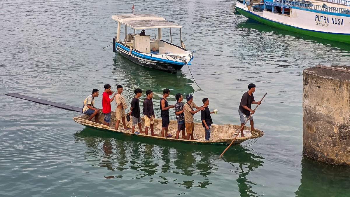 Men balancing and coordinating on a small boat without speaking