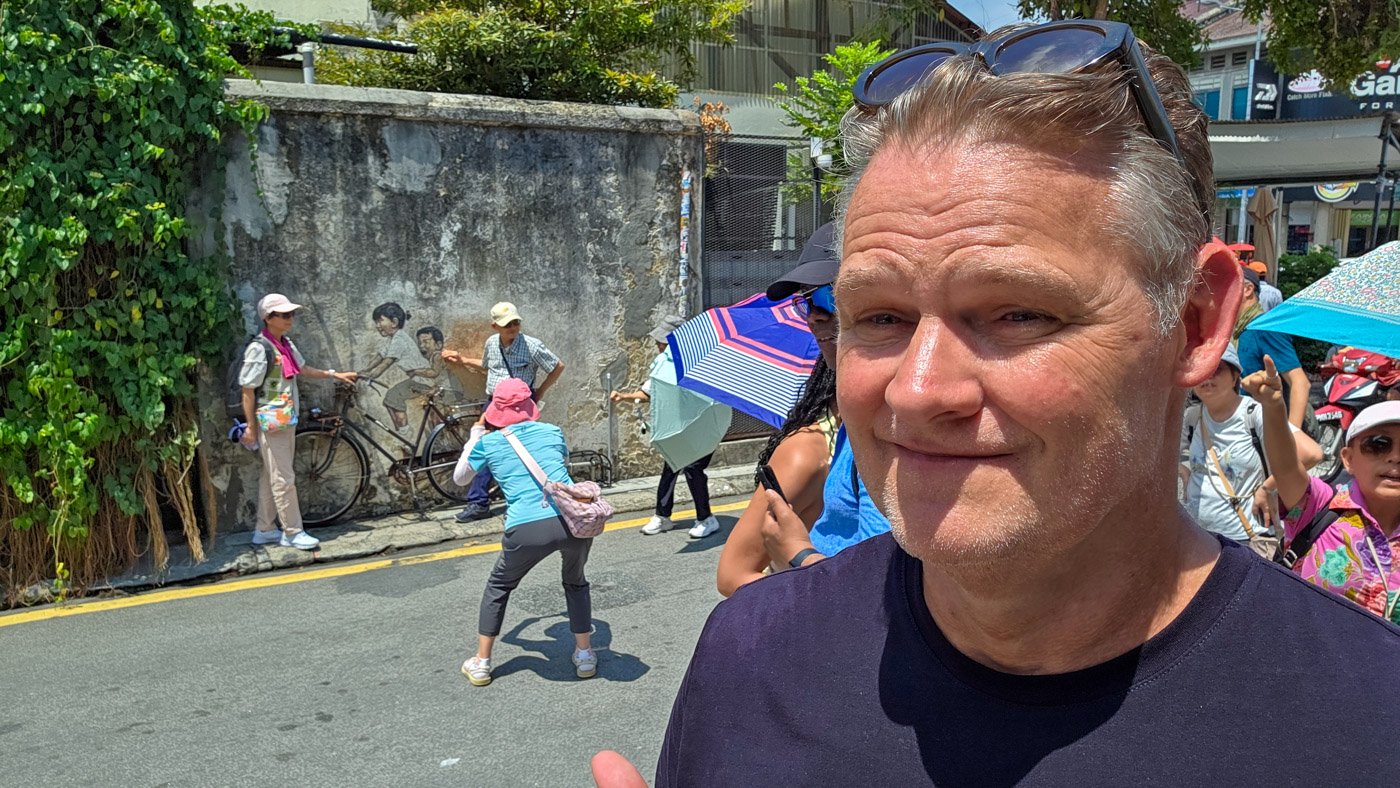 Martin in George Town with tourists photographing the famous bicycle street art in the background