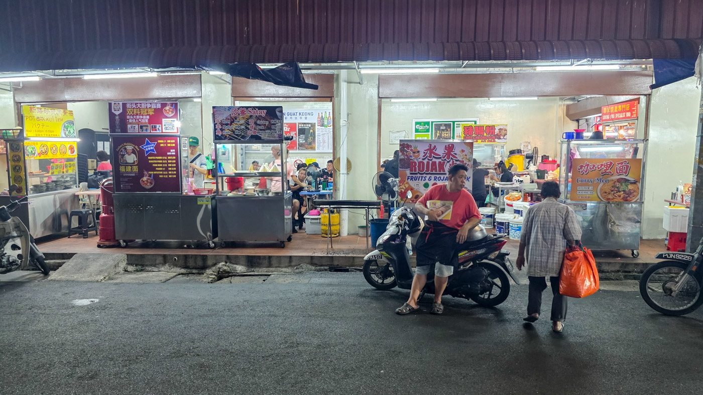 Street-side restaurant and food stalls in Penang with locals going about their daily routines