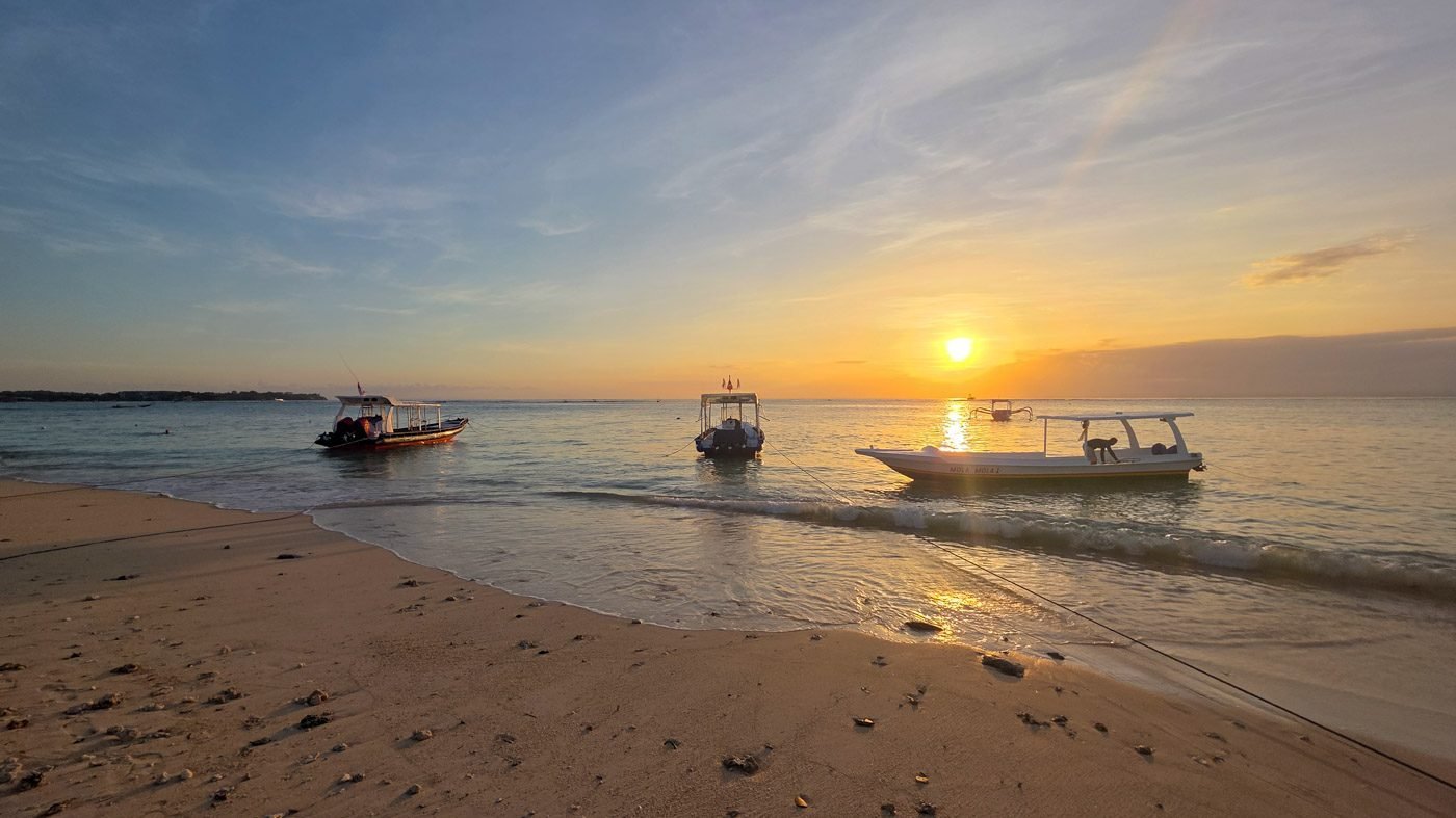 Fishing boats resting on the shore at sunset in Nusa Lembongan, Bali.