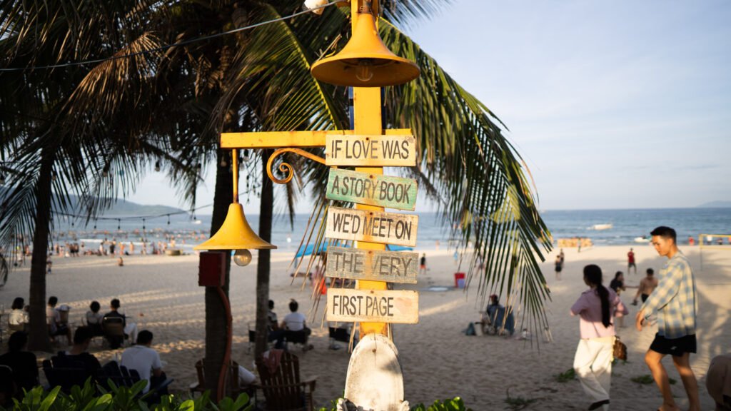 Sign on Da Nang beach reading "If love was a story book we will meet on the first page"