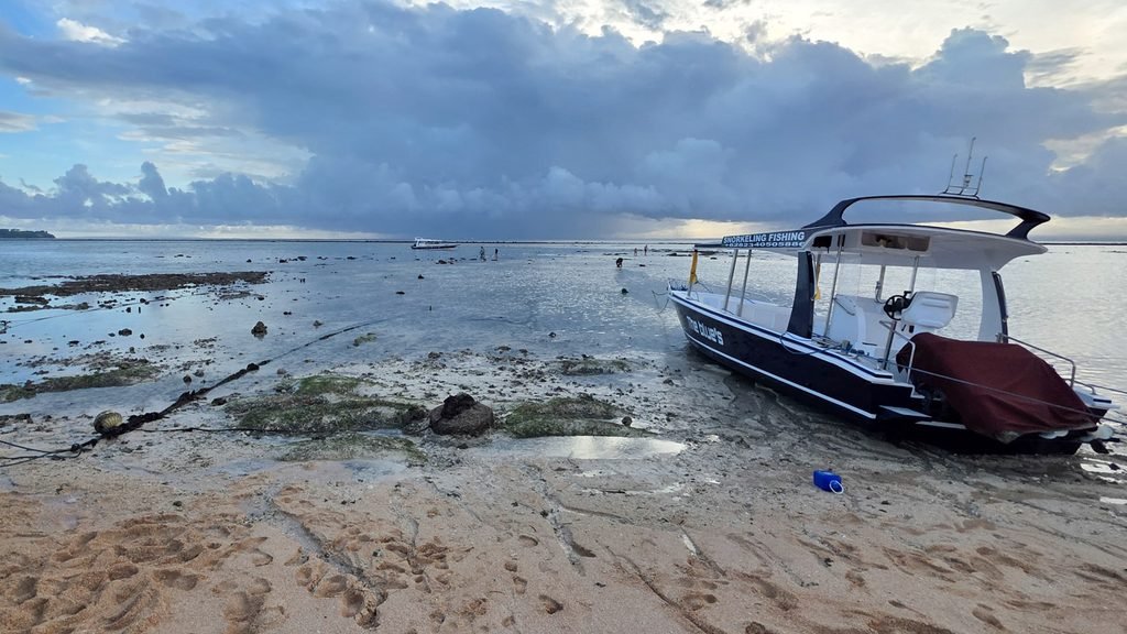 People walking across shallow water at low tide near Jungut Batu on Nusa Lembongan