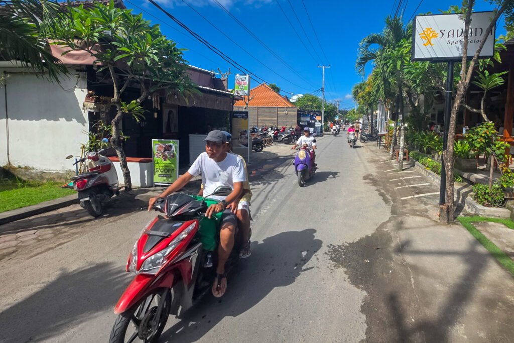 Motorcyclist riding along a quiet road in Jungut Batu on Nusa Lembongan