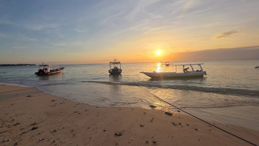 Sunset over the beach in Nusa Lembongan with boats resting near the shore.