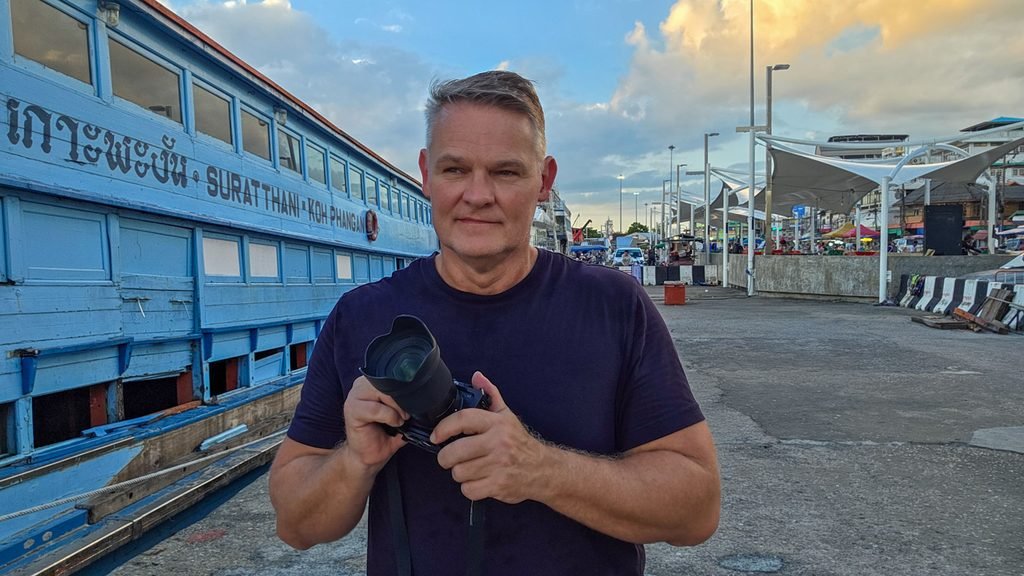 Martin Gram holding a Sony camera at the Surat Thani ferry terminal in southern Thailand.