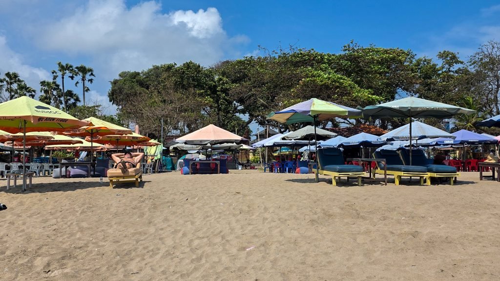 Rows of sun loungers on a beach in Bali, reflecting one of the island's more tourist-focused areas.
