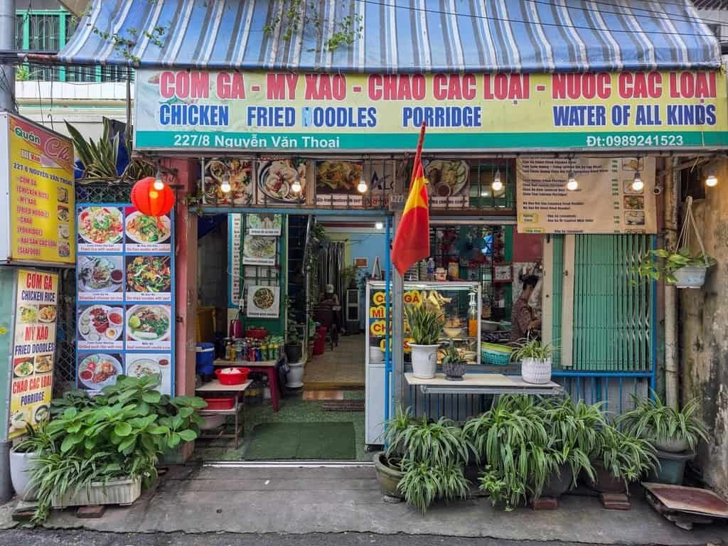 Small local restaurant in Da Nang, Vietnam with menu signs and outdoor seating